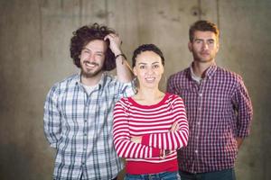 retrato de un equipo informal de negocios frente a un muro de hormigón foto