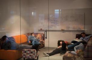 software developers sleeping on sofa in creative startup office photo