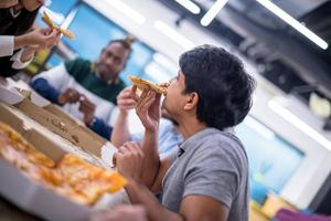 equipo de negocios multiétnico comiendo pizza foto