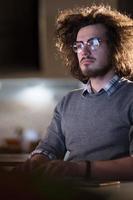 man working on computer in dark office photo