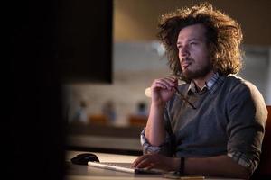 hombre trabajando en una computadora en una oficina oscura foto