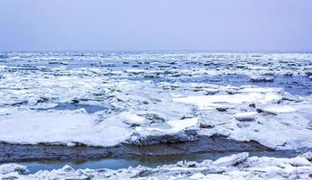 Frozen river sea on dike snow ice floes glate ice. photo
