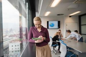 empresaria rubia que trabaja en la tableta en la oficina foto