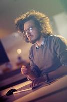 hombre trabajando en una computadora en una oficina oscura foto