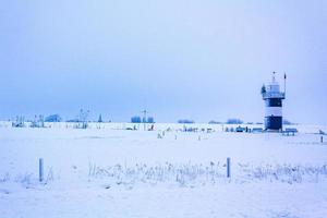 Light house at frozen dike snow ice floes glate ice. photo