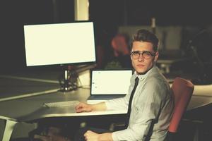 man working on computer in dark office photo