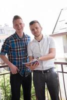 young men standing at balcony photo