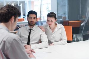 young couple signing contract documents on partners back photo