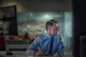 man working on computer in dark office photo