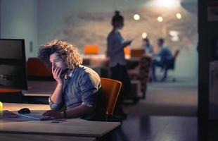 man working on computer in dark office photo