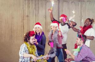 grupo multiétnico de empresarios casuales bailando con bengalas foto