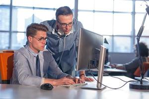 dos personas de negocios que trabajan con una computadora en la oficina foto