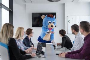 boss dresed as bear having fun with business people in trendy office photo