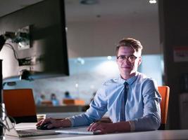 man working on computer in dark office photo