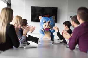 boss dresed as bear having fun with business people in trendy office photo