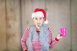 young business woman wearing a red hat and blowing party whistle photo