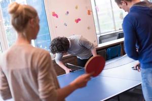 equipo de negocios de inicio jugando tenis de ping pong foto