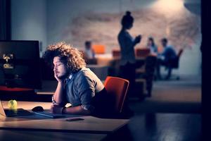 hombre trabajando en una computadora en una oficina oscura foto