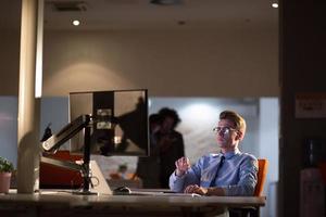 man working on computer in dark office photo