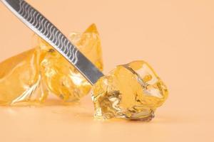 yellow wax with dabbing stick of cannabis resin for smoking high in THC photo