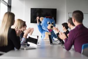 jefe vestido como oso divirtiéndose con gente de negocios en una oficina de moda foto