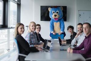 boss dresed as bear having fun with business people in trendy office photo