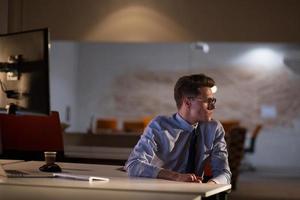 man working on computer in dark office photo