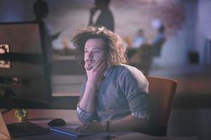 man working on computer in dark office photo