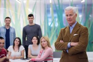 portrait of  teacher with students group in background photo