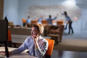 man using mobile phone in dark office photo