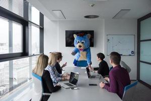 boss dresed as bear having fun with business people in trendy office photo