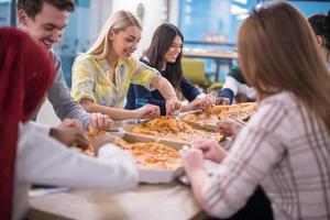 equipo de negocios multiétnico comiendo pizza foto