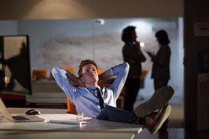 businessman sitting with legs on desk at office photo