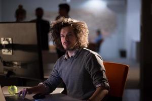 man working on computer in dark office photo