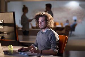 man working on computer in dark office photo