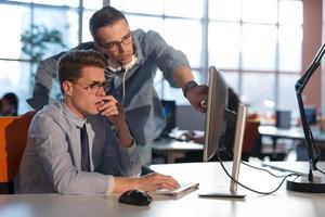 dos personas de negocios que trabajan con una computadora en la oficina foto