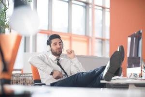 relaxed young business man at office photo