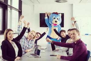 boss dresed as bear having fun with business people in trendy office photo