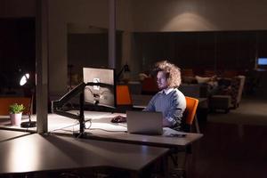 man working on computer in dark office photo