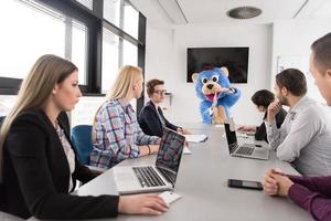 jefe vestido como oso divirtiéndose con gente de negocios en una oficina de moda foto