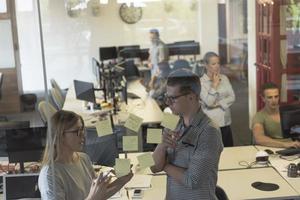 young couple at modern office interior writing notes on stickers photo