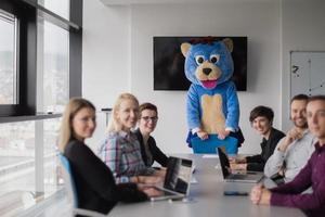 jefe vestido como oso divirtiéndose con gente de negocios en una oficina de moda foto