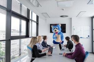 boss dresed as bear having fun with business people in trendy office photo