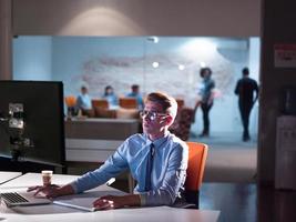 man working on computer in dark office photo