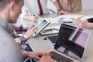 Cerca de las manos de un hombre de negocios usando una tableta en una reunión foto