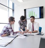 grupo de jóvenes empresarios reunidos en una oficina moderna foto