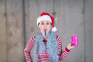 young business woman wearing a red hat and blowing party whistle photo