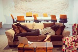 man sleeping on a sofa  in a creative office photo