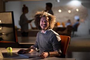 man working on computer in dark office photo