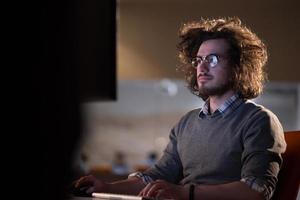 man working on computer in dark office photo